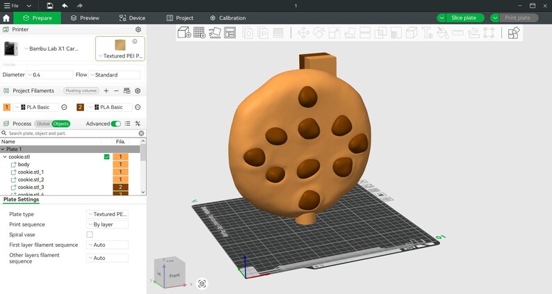 Puede incluir: Modelo 3D de una galleta marr&oacute;n claro con varios agujeros. El modelo se muestra sobre una cuadr&iacute;cula gris, con una interfaz de impresora 3D visible en el fondo.