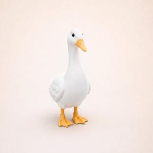 May include: A small white duck figurine with a smooth matte finish. The duck has a bright orange beak and matching orange webbed feet. It features two small black circular eyes and is standing in an upright position with its head turned slightly.