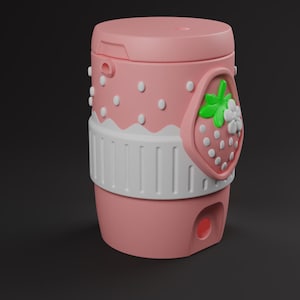 May include: A cylindrical pink container featuring a white scalloped band around the middle and a raised strawberry emblem with green leaves and white flowers. The upper section has small white dots, and a small circular opening is visible at the base.