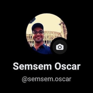 May include: A circular profile picture featuring a person wearing a dark cap and blue shirt, positioned in front of a large stone structure. Below the image, the text reads Semsem Oscar followed by the handle @semsem.oscar on a black background.