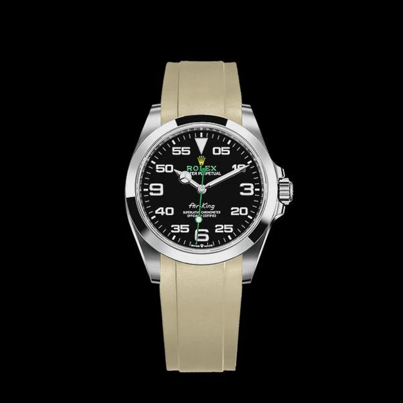May include: A Rolex Air King watch with a black dial, silver case, and beige band. The watch face displays the time with white numerals and hands. The watch is set against a black background.