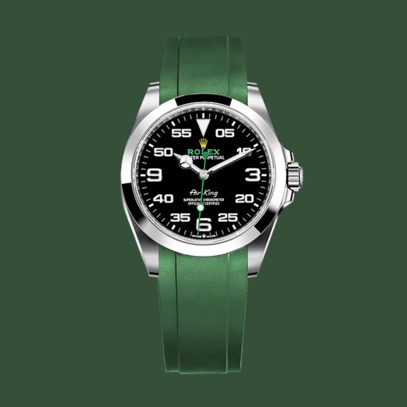 May include: A Rolex Air King watch with a black dial, silver bezel, and green rubber strap. The watch face displays white numerals and hands against a black background. The watch is set against a dark green backdrop.