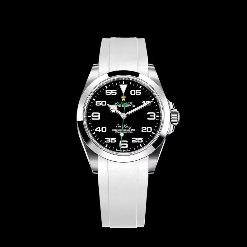 May include: A silver Rolex Air King watch with a black dial and white band. The watch face displays the Rolex logo, the words "Air King", and the time. The watch has a white band.