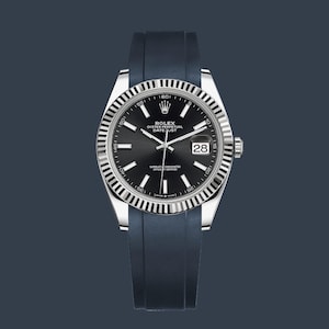 May include: A Rolex Oyster Perpetual Datejust watch with a black dial and a silver fluted bezel. It features a dark blue rubber strap. The watch face displays the date and the Rolex logo.