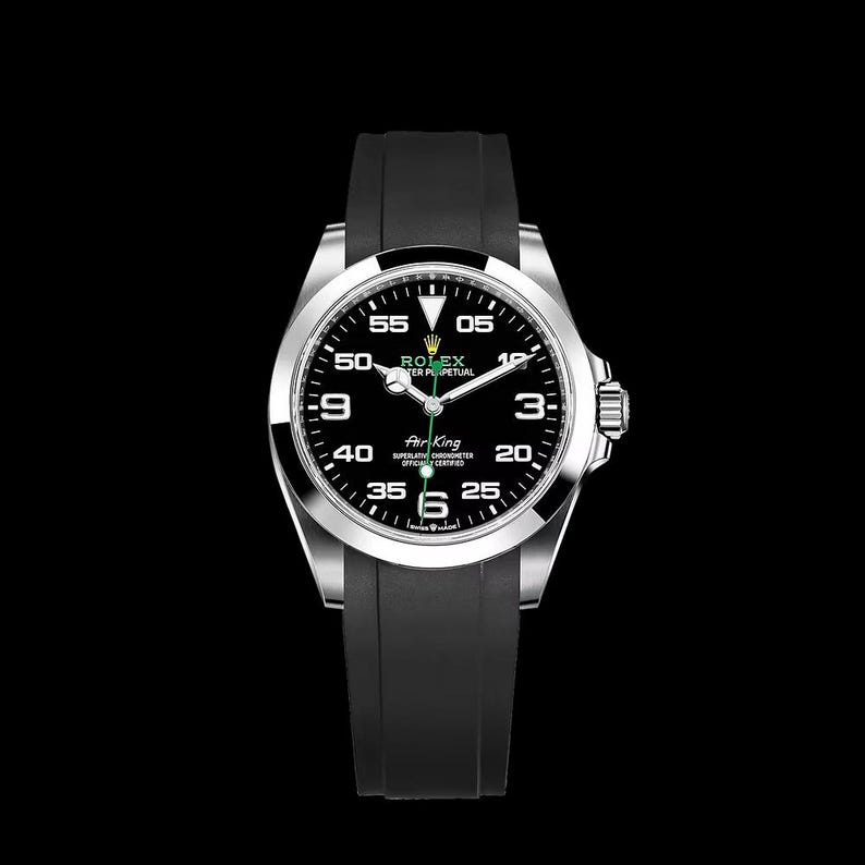 May include: A stainless steel Rolex Air King watch with a black dial and a black rubber strap. The watch face features white numerals, a green second hand, and the Rolex logo. The watch has a round face and a silver bezel.