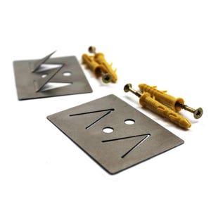 May include: Two metal picture hangers with angled slots and two yellow plastic wall anchors with screws. The hangers are rectangular and have a dark gray finish. The screws and anchors are yellow.