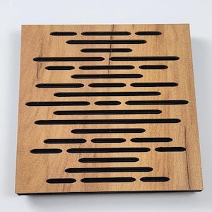 Könnte beinhalten: Ein quadratisches Akustikpaneel aus Holz mit hellbraunem Finish. Das Paneel weist eine Reihe von horizontalen und vertikalen Schlitzen auf, die in das Holz geschnitten sind und ein Muster bilden. Die Schlitze sind mit einem schwarzen Material gefüllt, wahrscheinlich zur Schallabsorption.