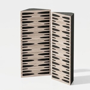 Op de afbeelding: Twee hoge, driehoekige akoestische panelen met een lichte houtnerfafwerking aan de voorzijde. Elk paneel heeft een reeks horizontale, langwerpige, zwarte ovale uitsparingen die in een herhalend patroon zijn gerangschikt.