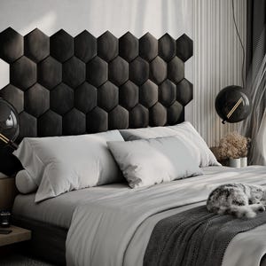 Puede incluir: Un dormitorio moderno con una cama con cabecero gris oscuro compuesto por paneles hexagonales. La cama est&aacute; cubierta con ropa de cama gris claro y una manta gris oscuro. Dos l&aacute;mparas colgantes negras en forma de globo cuelgan del techo. Un gato est&aacute; durmiendo en la cama.