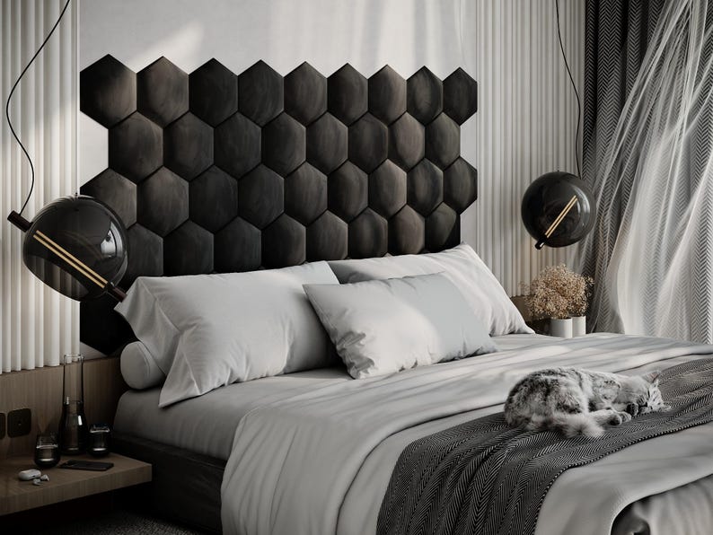 Puede incluir: Un dormitorio moderno con una cama con cabecero gris oscuro compuesto por paneles hexagonales. La cama est&aacute; cubierta con ropa de cama gris claro y una manta gris oscuro. Dos l&aacute;mparas colgantes negras en forma de globo cuelgan del techo. Un gato est&aacute; durmiendo en la cama.