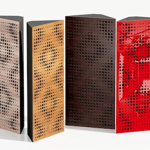 Op de afbeelding: Vier moderne, driehoekige luidsprekers. De luidsprekers hebben een geperforeerd ontwerp en zijn verkrijgbaar in licht hout, natuurlijk hout, donkerbruin en glanzend rood. Elke luidspreker heeft een zwarte bovenkant en zijkanten.