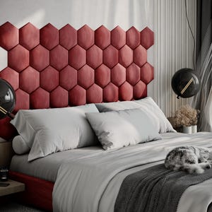 Puede incluir: Un dormitorio moderno con una cama con un cabecero rojo y geom&eacute;trico. La cama est&aacute; hecha con s&aacute;banas y almohadas blancas, y una manta gris. Un gato est&aacute; durmiendo en la cama. Luces colgantes negras en forma de globo cuelgan del techo.
