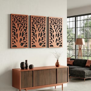 Puede incluir: Tres paneles de arte mural de color cobre con recortes de ramas de árboles, montados en una pared blanca. Debajo, un mueble de madera con puertas correderas y jarrones decorativos. La habitación presenta un diseño moderno con un sofá y grandes ventanales.