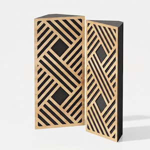 Op de afbeelding: Twee hoge, driehoekige akoestische panelen met een lichtgekleurde houten roosterlaag in een geometrisch patroon van kruisende diagonale lijnen. De panelen hebben een donkergekleurde achterkant die zichtbaar is door de open ruimtes.