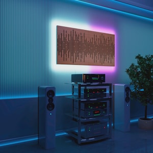 Könnte beinhalten: Moderne Heim-Audioanlage mit einer Holz-Schallwand mit schwarzem Muster, umrahmt von einem Neonlichtrahmen. Darunter ein Rack mit Audio-Geräten, flankiert von zwei weißen Lautsprechern. Der Raum hat ein blau-violettes Farbschema.
