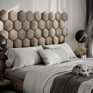 Puede incluir: Un dormitorio moderno con una cama grande con cabecero geom&eacute;trico. La cama est&aacute; cubierta con ropa de cama gris claro y una manta gris oscura. Un gato est&aacute; durmiendo en la cama. L&aacute;mparas colgantes decorativas en forma de globo cuelgan.