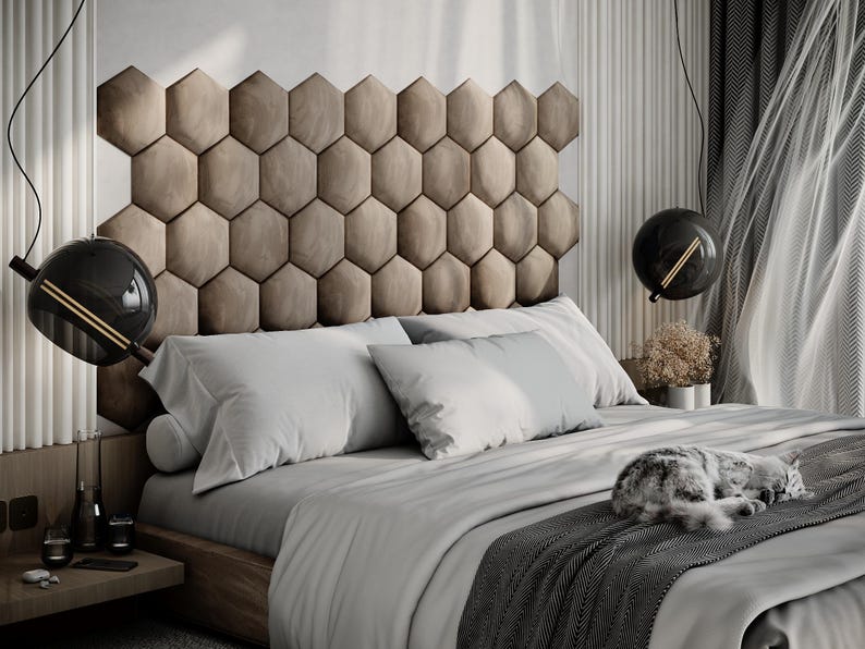 Puede incluir: Un dormitorio moderno con una cama grande con cabecero geom&eacute;trico. La cama est&aacute; cubierta con ropa de cama gris claro y una manta gris oscura. Un gato est&aacute; durmiendo en la cama. L&aacute;mparas colgantes decorativas en forma de globo cuelgan.