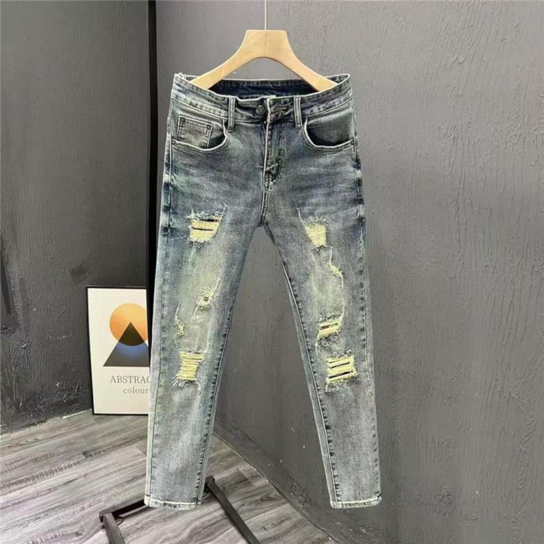 Men's Ripped Denim Jeans | High Waisted Distressed Pants | Streetwear Y2k Vintage Fashion
.
A pair of men's ripped denim jeans with a relaxed, distressed design and streetwear-inspired silhouette. The jeans feature a loose fit, visible rips, and casual styling ideal for Y2K, grunge, or vintage outfits.