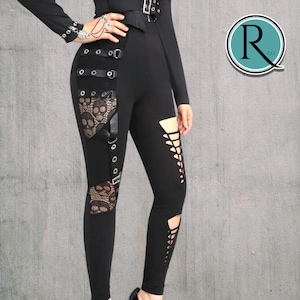 May include: Black leggings with lace skull detailing and cut-out features. The leggings have multiple buckles and straps, creating a gothic or punk aesthetic. The design incorporates a combination of textures and patterns.