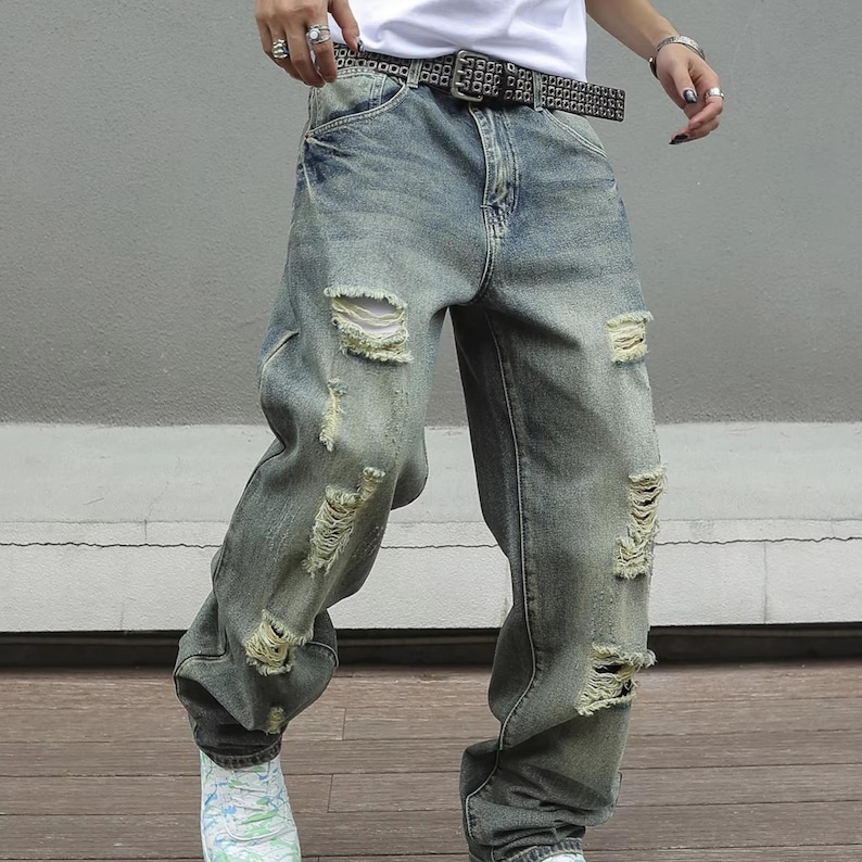 Men's Ripped Denim Jeans | High Waisted Distressed Pants | Streetwear Y2k Vintage Fashion
.
A pair of men's ripped denim jeans with a relaxed, distressed design and streetwear-inspired silhouette. The jeans feature a loose fit, visible rips, and casual styling ideal for Y2K, grunge, or vintage outfits.