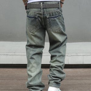 Men's Ripped Denim Jeans | High Waisted Distressed Pants | Streetwear Y2k Vintage Fashion
.
A pair of men's ripped denim jeans with a relaxed, distressed design and streetwear-inspired silhouette. The jeans feature a loose fit, visible rips, and casual styling ideal for Y2K, grunge, or vintage outfits.