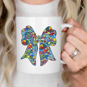May include: A white ceramic mug with a black handle and the text "But First, Coffee" in a handwritten style. The mug is on a white surface. The mug is approximately 4 inches tall.