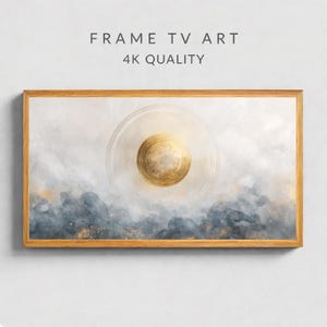 May include: A framed artwork with a gold and blue abstract design. The artwork features a central gold circle with concentric rings, set against a backdrop of blue and white watercolor-style clouds. The frame is made of light-colored wood. Text at the top reads "FRAME TV ART 4K QUALITY."
