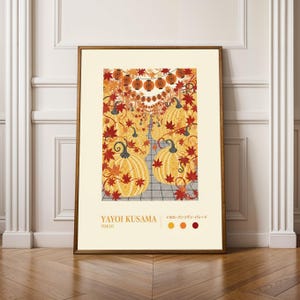 May include: A framed art print depicting yellow pumpkins with black stems, red maple leaves, and strings of orange lanterns. The print includes the text "YAYOI KUSAMA TOKYO".