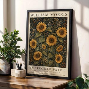 May include: A framed art print titled William Morris Sunflower Patch, featuring a dark background with yellow sunflowers and small white flowers. The text reads William Morris, Sunflower Patch, An Exhibition of Arts & Crafts, London, Est. 1880.