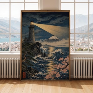 May include: Framed print depicting a lighthouse on a cliff, with a beam of light illuminating the sea. The artwork shows a mountain in the background, with waves and cherry blossoms in the foreground. The colour scheme includes blues, greens, and browns.