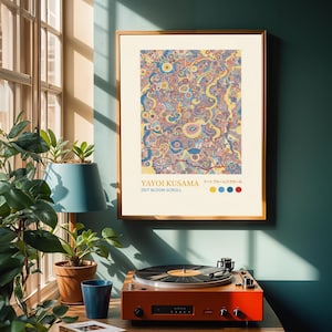 Könnte beinhalten: Eine weiße Keramik-Tasse mit schwarzem Henkel und dem Text "But First, Coffee" in fetter, schwarzer Schrift. Die Tasse steht vor einem verschwommenen Hintergrund, der ihr schlichtes Design hervorhebt.