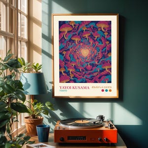 Puede incluir: Una impresión artística enmarcada con un vibrante diseño de hongos psicodélicos en tonos morados, rosas y azules. La impresión incluye el texto "YAYOI KUSAMA TOKYO" y texto japonés. Un tocadiscos vintage se encuentra debajo.