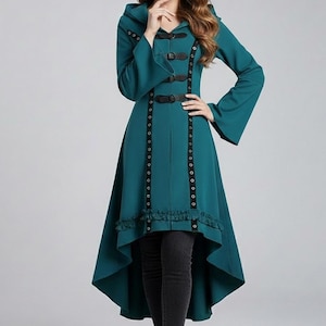 May include: Teal hooded coat with long sleeves and a high-low hemline. The coat has black leather-look straps and decorative rivets down the front. It features a ruffled hem and a flared silhouette, creating a unique, stylish look. The coat is a fashionable garment.