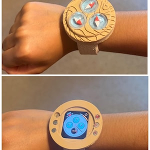May include: A beige 3D-printed watch case accessory featuring a textured circular frame with three small compasses on the top side and a central cutout for a smartwatch display. The frame includes small circular accents on the side edges.