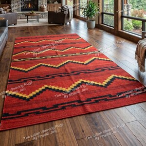 Puede incluir: Una alfombra rectangular roja con un patrón geométrico de zigzags amarillos y negros. La alfombra está colocada sobre un suelo de madera en un salón. El texto "The Indian Weaving Rugs By Shaifali Jain" es visible en las esquinas.