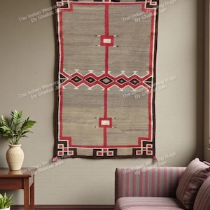 Può includere: Tappeto rettangolare da parete con sfondo grigio e motivi geometrici rossi e neri. Il tappeto ha un bordo marrone ed è appeso a una parete beige. The Indian Weaving Rugs By Shaifali Jain è stampato sul tappeto.