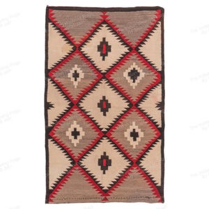 Op de afbeelding: Rechthoekig geweven vloerkleed met een geometrisch ruitpatroon. Het vloerkleed heeft afwisselende ruiten in beige, grijs en rood, omlijnd met zwart. Het vloerkleed heeft een donkere rand en is waarschijnlijk handgemaakt.