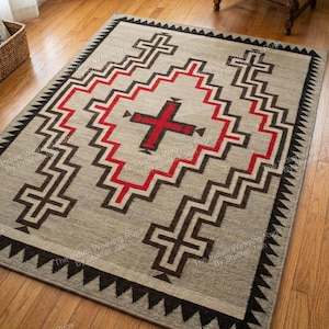May include: A rectangular beige rug with a geometric pattern. The design features a central red cross shape surrounded by zig-zag lines in red and brown. The border is black with triangular shapes. The rug is on a wooden floor.
