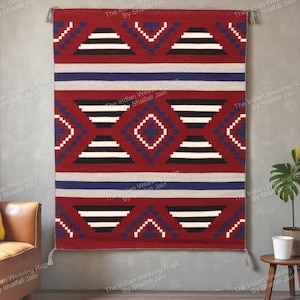 Può includere: Un arazzo da parete rettangolare rosso tessuto con motivi geometrici. Il design include triangoli e rombi bianchi, neri e blu, con strisce orizzontali. Il testo "The Indian Weaving Rugs By Shaifali Jain" è stampato.