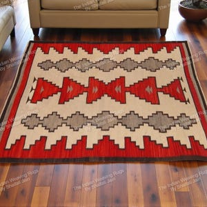 Può includere: Tappeto rettangolare con un motivo geometrico in rosso, crema, grigio e nero. Il tappeto presenta un design ripetuto di triangoli a gradini e forme a diamante, adatto per un soggiorno o una camera da letto. Il tappeto è posato su un pavimento in legno.