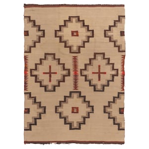 Può includere: Un tappeto rettangolare beige con un motivo geometrico. Il design presenta forme a diamante ripetute in tonalità marroni e grigie, con accenti di croci rosse. Il tappeto ha un bordo sfrangiato e un bordo marrone scuro.