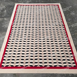 Può includere: Tappeto rettangolare con un motivo geometrico a forma di diamante nero, beige e marrone chiaro. Il tappeto ha un bordo rosso e un bordo esterno beige. Il tappeto è adatto per soggiorni e camere da letto.