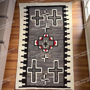 Può includere: Tappeto rettangolare grigio con un disegno geometrico a croce. Il tappeto presenta quattro grandi croci e un motivo centrale a diamante con accenti rossi. Il bordo è bianco e nero e il tappeto è posto su un pavimento in legno.