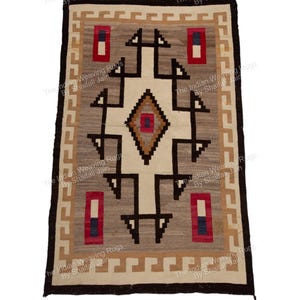 Può includere: Tappeto rettangolare tessuto con un design geometrico. Il tappeto presenta una forma a diamante centrale color crema con un diamante marrone e rosso al centro. Il bordo è marrone, con un motivo ripetuto in beige e crema. Il testo "The Indian Weaving Rugs By Shaifali Jain" si ripete.