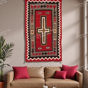 Può includere: Un arazzo da parete rettangolare, tessuto rosso e nero con un motivo a croce centrale. Il tappeto presenta motivi geometrici nelle tonalità del rosso, marrone, grigio e bianco. Il testo "The Indian Weaving Rugs By Shafali Jain" è visibile.