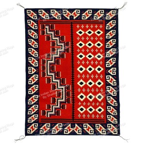 Pode incluir: Um tapete retangular tecido à mão com um campo central vermelho vibrante. O tapete apresenta padrões geométricos em preto, branco e cinza, com uma borda azul escuro. O design inclui ziguezagues, losangos e cruzes. Tassels são visíveis na parte superior e inferior.