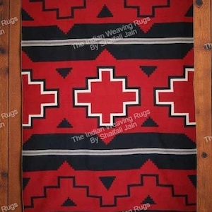 Può includere: Un tappeto rettangolare tessuto rosso, nero e bianco con motivi geometrici. Il tappeto presenta un disegno centrale a forma di croce e motivi a gradini ripetuti. Il testo "The Indian Weaving Rugs By Shaifali Jain" è visibile.