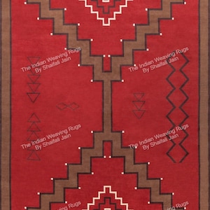May include: A rectangular red rug with a geometric pattern in brown, white, and black. The design features stepped lines and diamond shapes. The text "The Indian Weaving Rugs By Shaifali Jain" is repeated around the border.