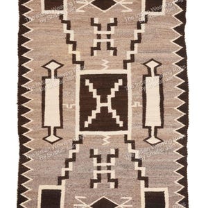 Può includere: Tappeto rettangolare tessuto con un motivo geometrico nei toni del marrone, grigio e bianco. Il design presenta quadrati, diamanti e linee a gradini. I bordi hanno un bordo a zig-zag.