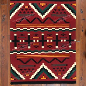 Può includere: Tappeto rettangolare rosso con motivi geometrici bianchi, neri, verdi e gialli. Il tappeto presenta un disegno centrale con forme a croce e bordi a zig-zag. Il testo "The Indian Weaving Rugs By Shaifali Jain" è stampato.